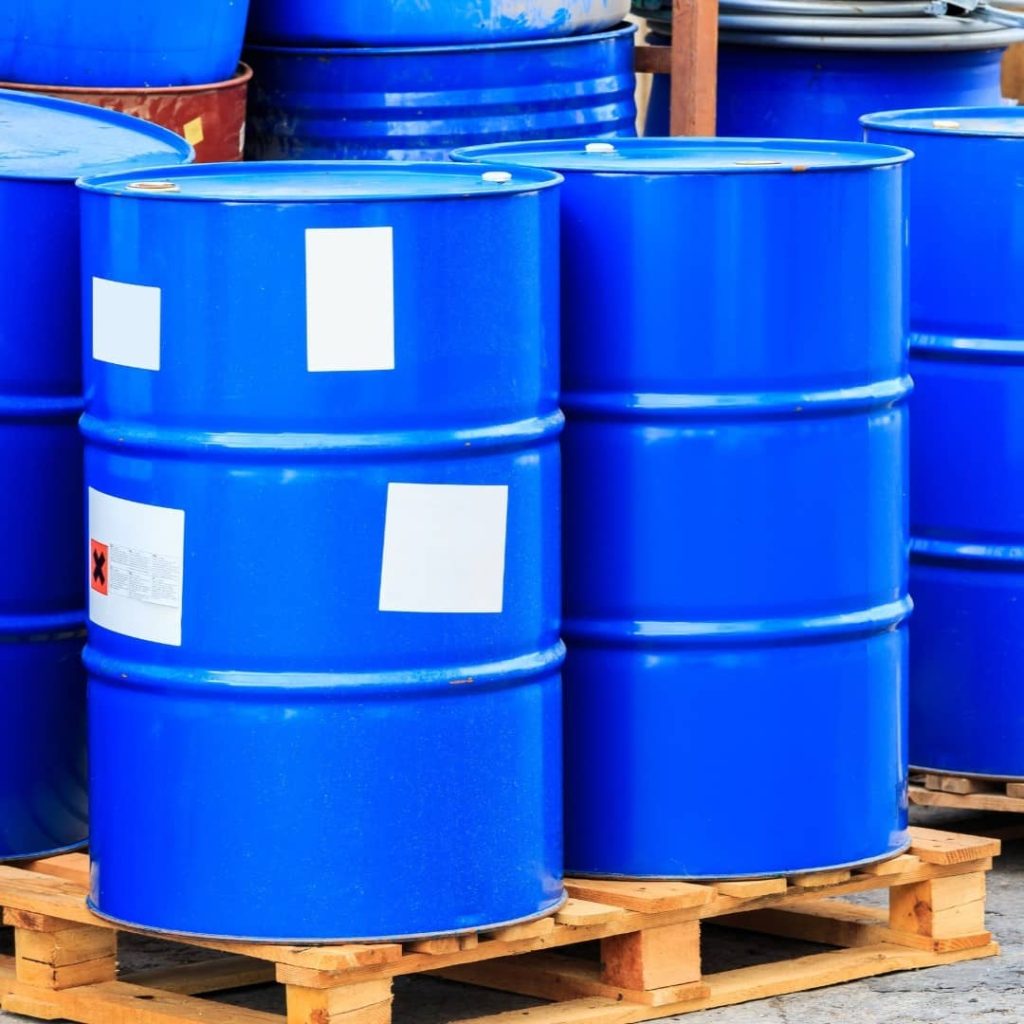 Blue industrial oil drums securely placed on heavy-duty wooden pallets for oil and gas industry storage and transport