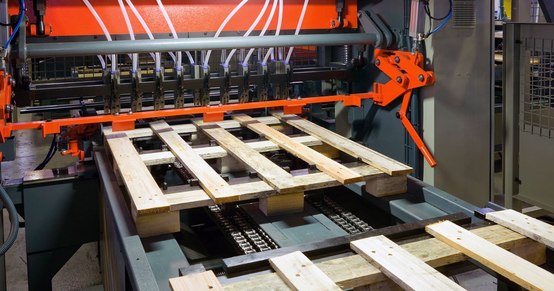 Automated Pallet Nailing and Conveyor Machinery Automated wooden pallet assembly conveyor line with orange multi-head nailing machine